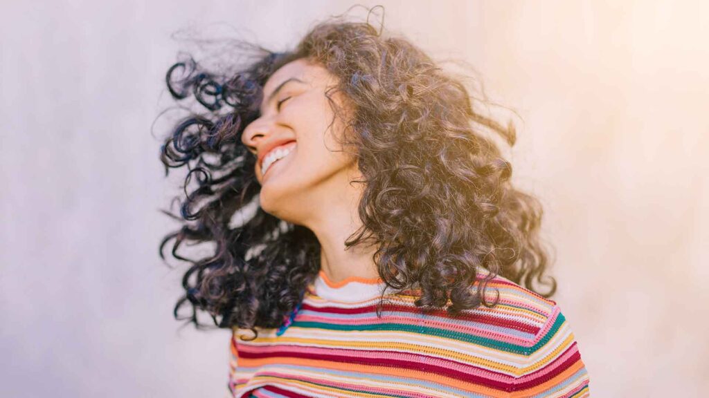 a woman with curly hair smiling