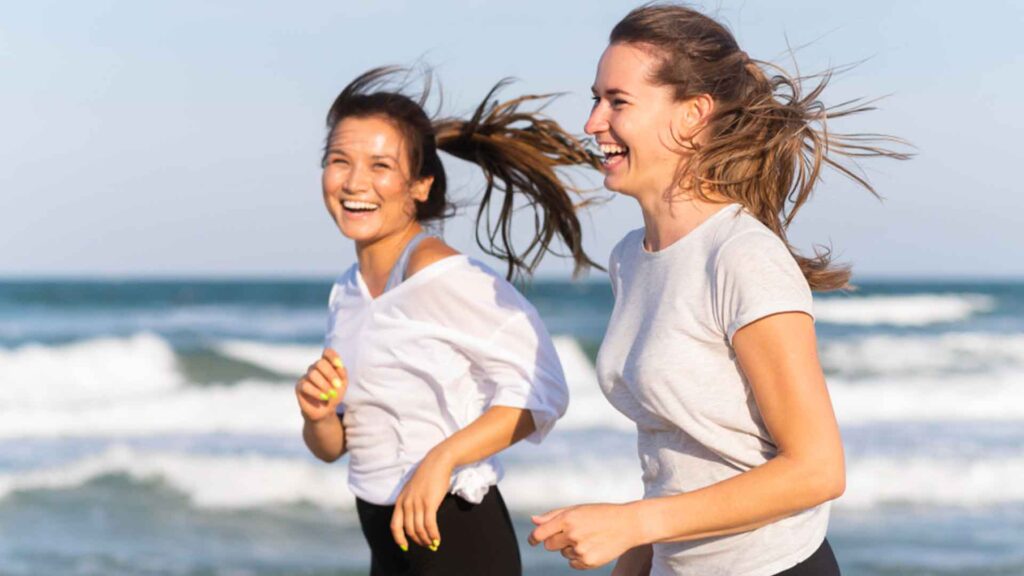 two women running on the beach