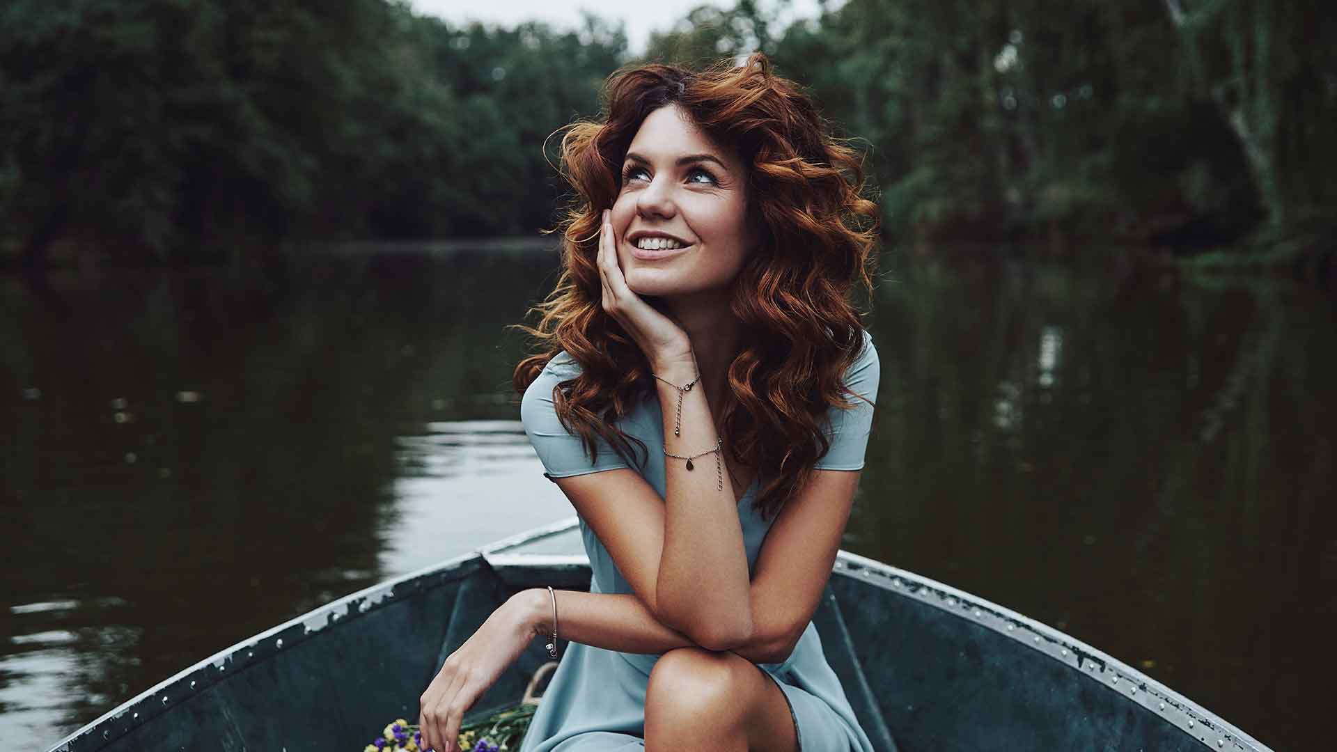 a woman sitting in a boat with a bouquet of flowers