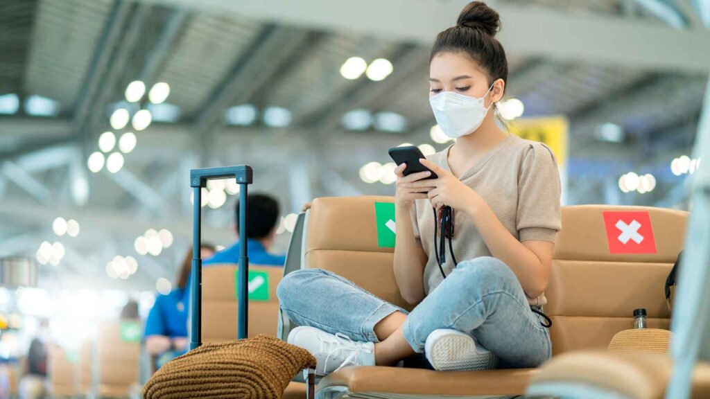 a woman wearing a face mask while using a phone